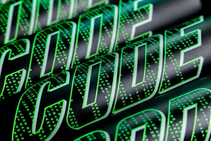Close-up of the word CODE in large, bold, green letters with a matrix-style digital pattern—resembling etchings on a 2025 Marucci Code (-8) USSSA Baseball Bat—set against a dark background.