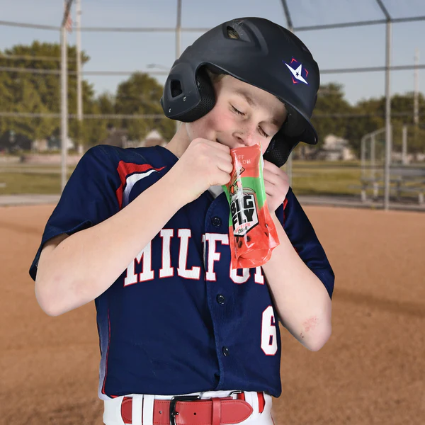 A young All-Star player in a navy blue MILFORD jersey stands ready for action, gripping his bat with All Star Big Fly Bat Tack Spray (BFSP1) by All Star brand on the field.