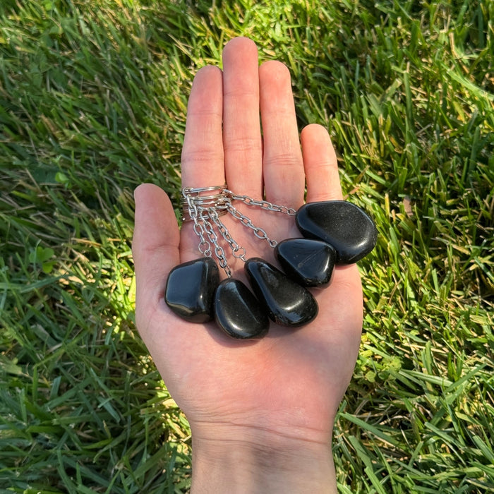 Three Black Obsidian keychains on a grassy backgroud