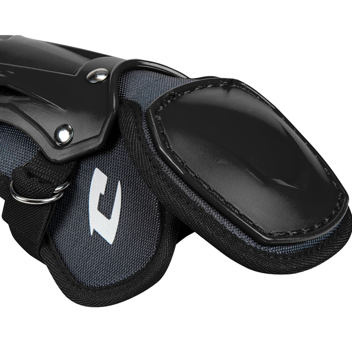 A close-up of Champro Optimus Pro Catcher's Leg Guards (CG18) by Champro Sports showing black and gray protective gear with hard plastic outer shells, a PE shin plate, and fabric straps for athletic leg protection.
