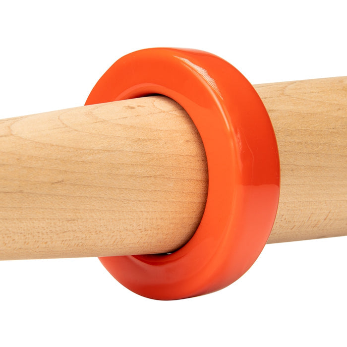 A Champro Sports Bat Weight (A014-A019), a glossy orange ring, is placed around a smooth, light wooden training bat against a white background.