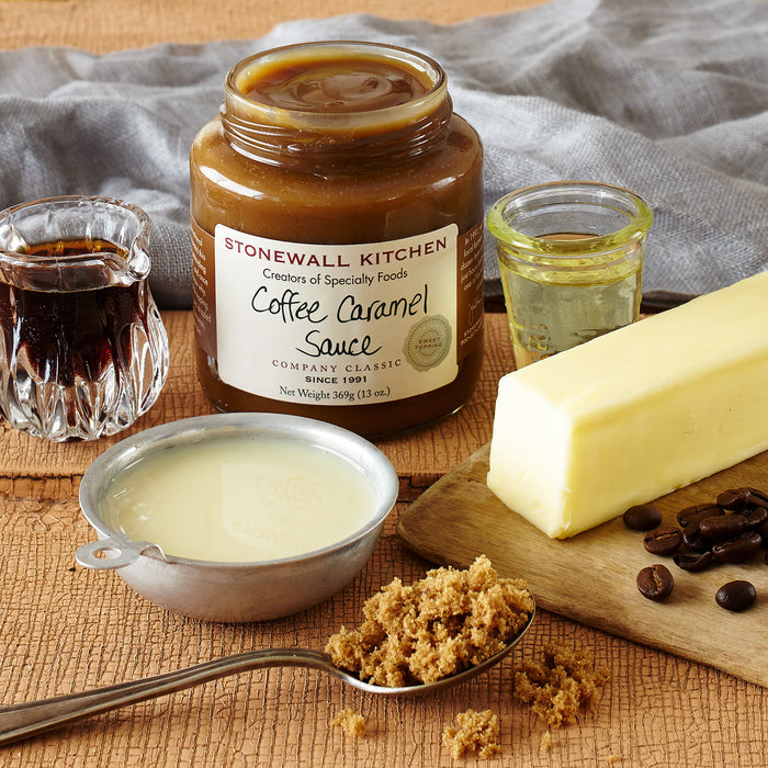 open jar of stonewall kitchen coffee caramel sauce with spoonful of brown sugar butter coffee beans milk and vanilla