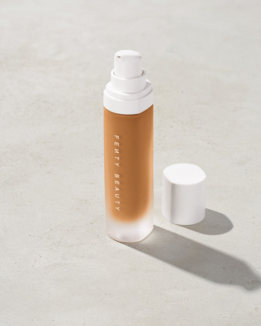 open bottle of Fenty Beauty Pro Filt'r Soft Matte Longwear Foundation with pump dispenser in shade 390 on concrete background