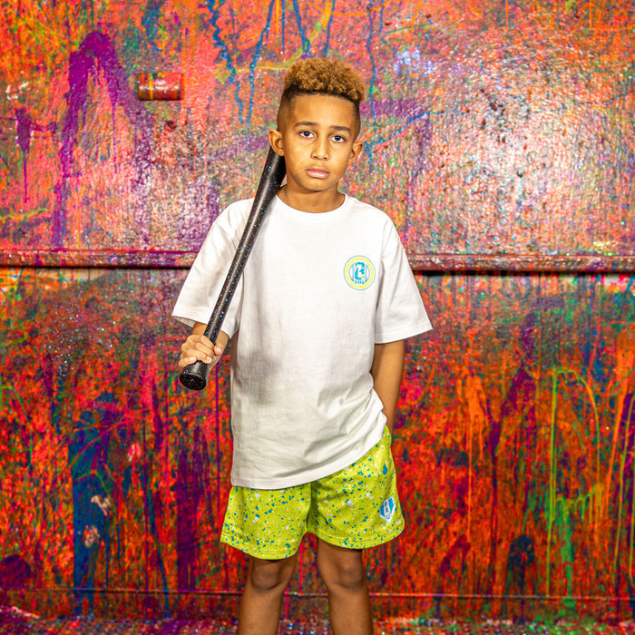 Child holding a baseball bat in front of a colorful, textured wall